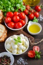 Italian food ingredients Ã¢â¬â mozzarella, tomatoes, basil and olive oil on rustic wooden table. Royalty Free Stock Photo